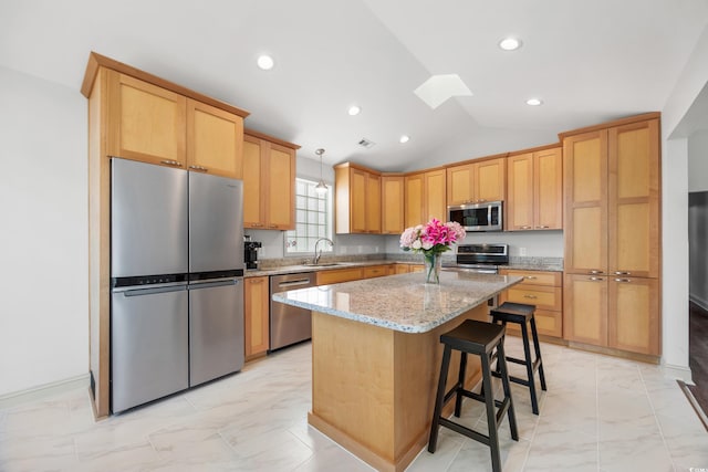 kitchen with light stone counters, a kitchen island, pendant lighting, stainless steel appliances, and sink