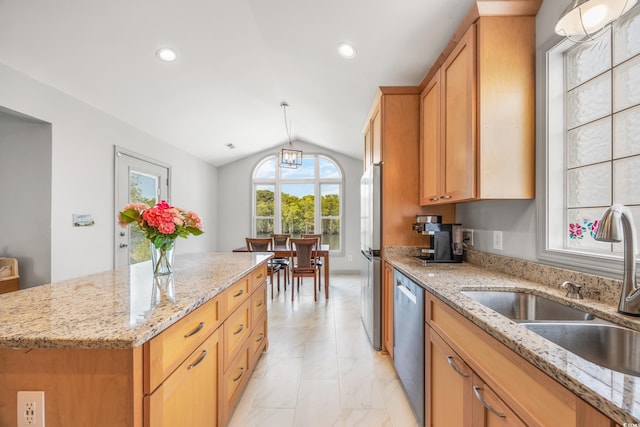 kitchen featuring light stone counters, lofted ceiling with skylight, appliances with stainless steel finishes, and sink