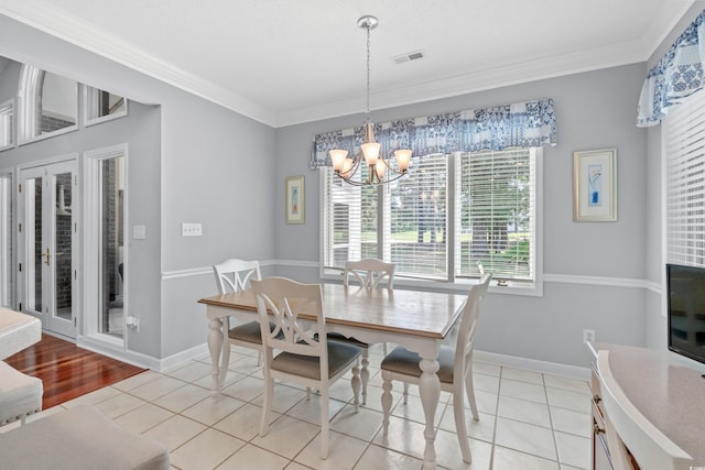 tiled dining area featuring an inviting chandelier and ornamental molding