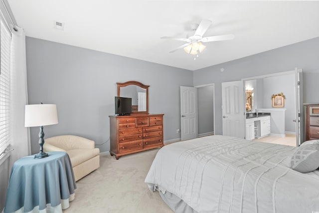 carpeted bedroom with ensuite bathroom and ceiling fan