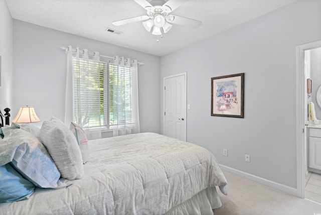 carpeted bedroom with a textured ceiling and ceiling fan