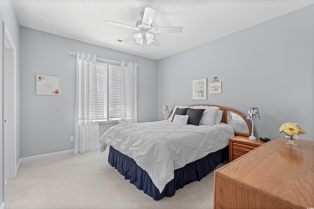 bedroom featuring light colored carpet, ceiling fan, and a textured ceiling