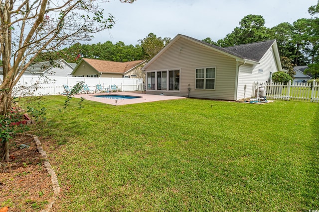 back of house featuring a yard, a patio area, a fenced in pool, and a fenced backyard