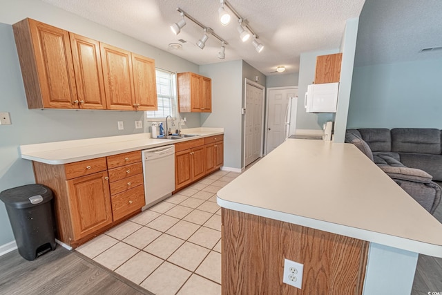 kitchen with a sink, visible vents, a textured ceiling, and dishwasher