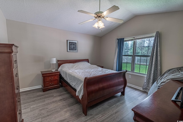 bedroom featuring a textured ceiling, vaulted ceiling, wood-type flooring, and ceiling fan