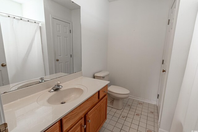 bathroom featuring tile patterned flooring, toilet, and vanity