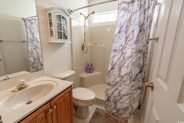 bathroom featuring tile patterned flooring, a shower with shower curtain, toilet, and vanity