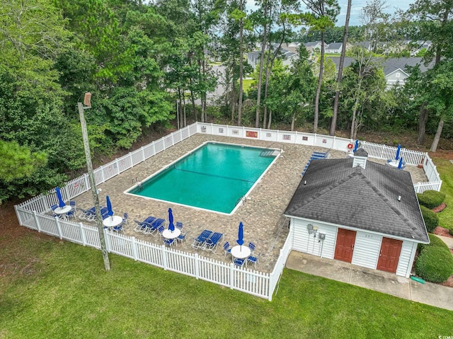 pool with a lawn and a fenced backyard