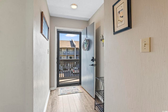 doorway to outside with baseboards and wood finished floors