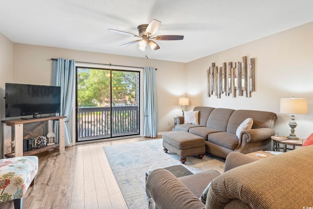 living room featuring wood finished floors, a ceiling fan, and baseboards