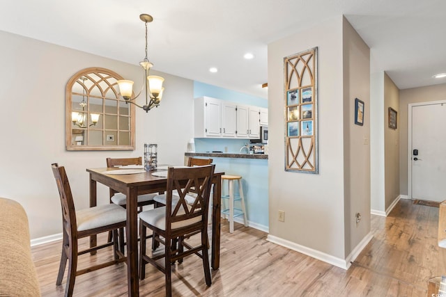 dining space with light wood-style flooring, baseboards, and recessed lighting