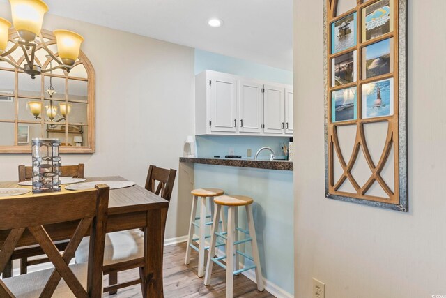 dining space featuring hardwood / wood-style flooring and a notable chandelier