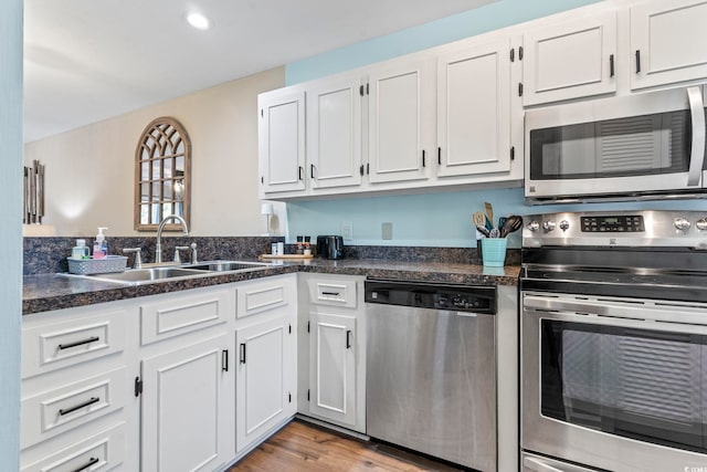 kitchen featuring stainless steel appliances, white cabinets, and a sink