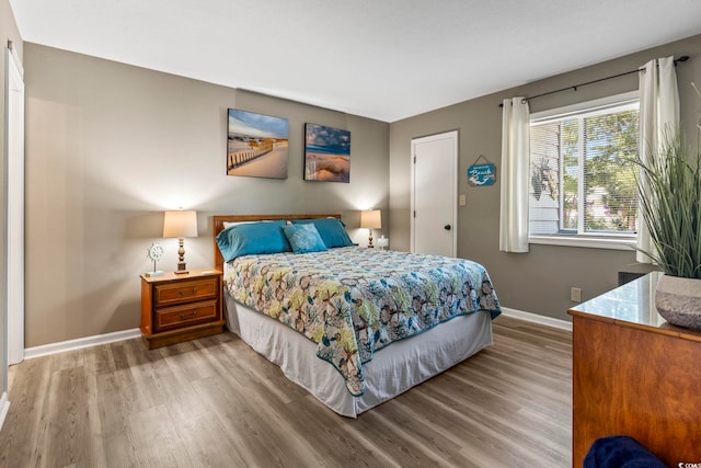 bedroom featuring baseboards and wood finished floors