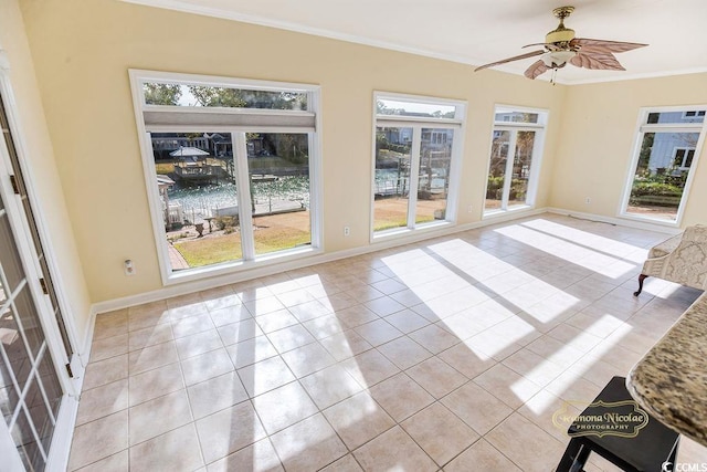 unfurnished sunroom with a water view, a wealth of natural light, and ceiling fan