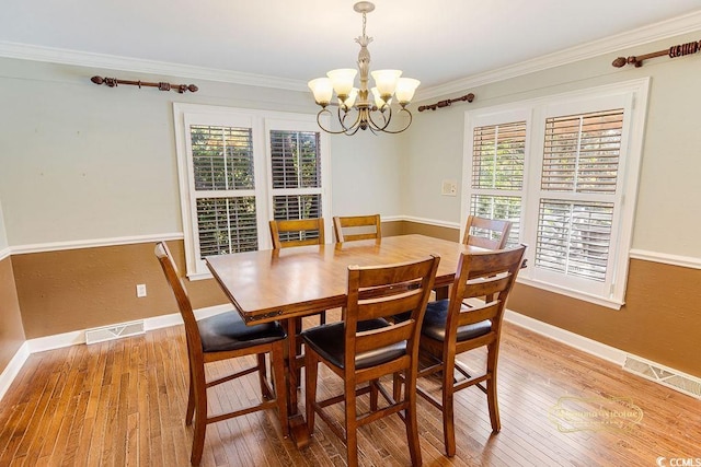 dining room with hardwood / wood-style floors, a chandelier, and ornamental molding