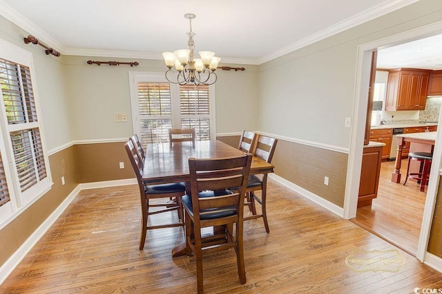 dining room featuring light wood-type flooring, crown molding, and a notable chandelier