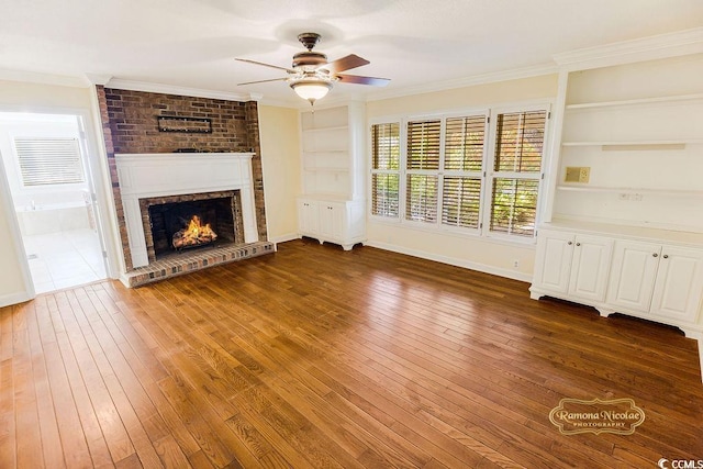 unfurnished living room featuring built in features, dark wood-type flooring, and a brick fireplace