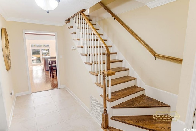 stairs with tile patterned floors and crown molding