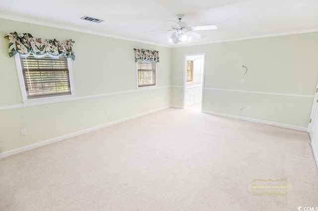 carpeted empty room featuring a wealth of natural light, ornamental molding, and ceiling fan