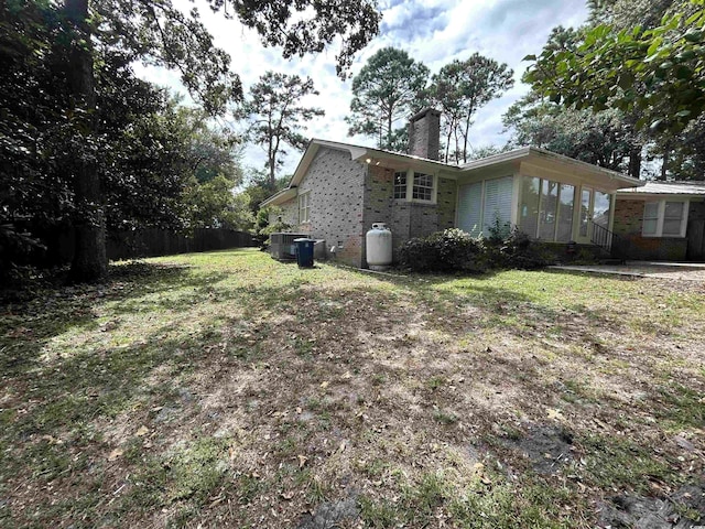 902 N 11th Ave N, North Myrtle Beach, SC 29582 - view of side of property with brick siding, fence, a chimney, and cooling unit