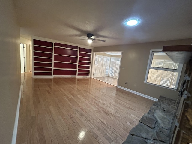 unfurnished living room with wood-type flooring and ceiling fan