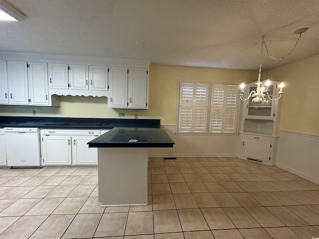 kitchen with white cabinetry, dishwasher, hanging light fixtures, a notable chandelier, and kitchen peninsula