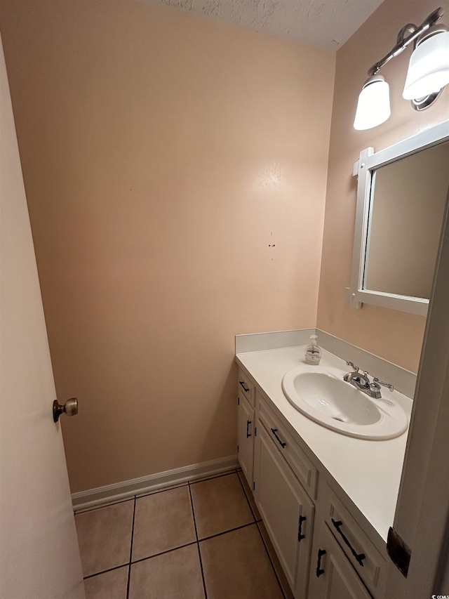 bathroom with tile patterned flooring, vanity, and a textured ceiling