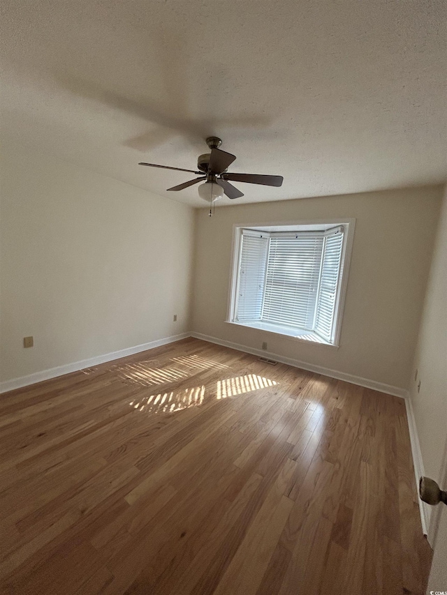 902 N 11th Ave N, North Myrtle Beach, SC 29582 - empty room featuring a textured ceiling, baseboards, a ceiling fan, and wood finished floors