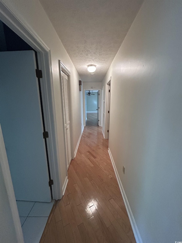 902 N 11th Ave N, North Myrtle Beach, SC 29582 - corridor featuring light wood-type flooring, a textured ceiling, and baseboards