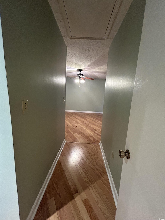 hall with light hardwood / wood-style flooring and a textured ceiling