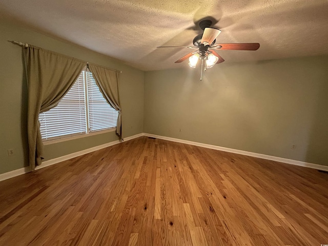 empty room with hardwood / wood-style floors, a textured ceiling, and ceiling fan