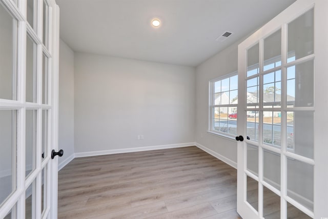 spare room with french doors and light wood-type flooring