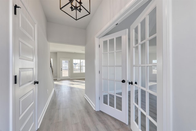 hall with french doors and light hardwood / wood-style floors