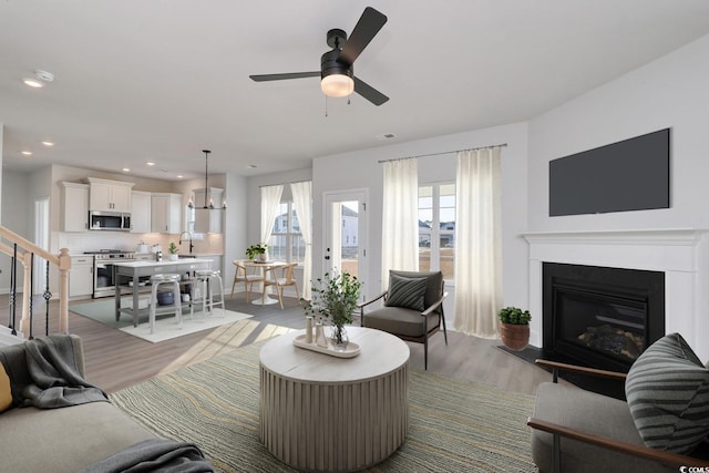 living room with sink, light hardwood / wood-style flooring, and ceiling fan