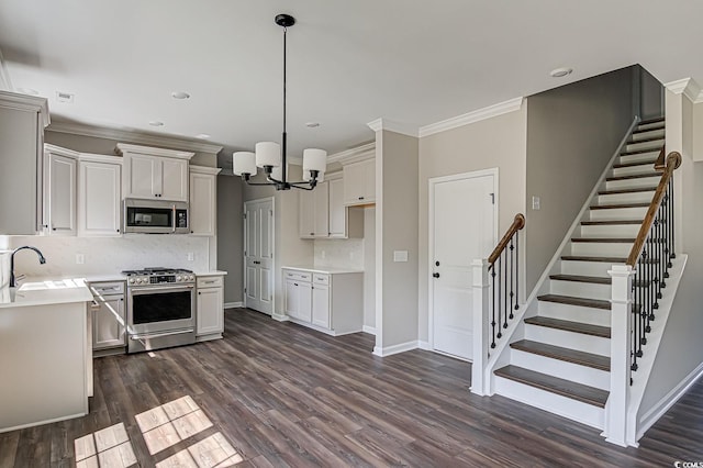 kitchen featuring sink, stainless steel appliances, dark hardwood / wood-style floors, pendant lighting, and decorative backsplash