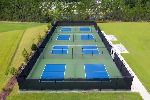 view of tennis court featuring a lawn