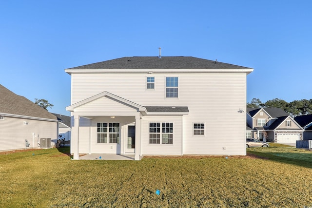 back of house featuring central AC unit, a patio area, and a lawn