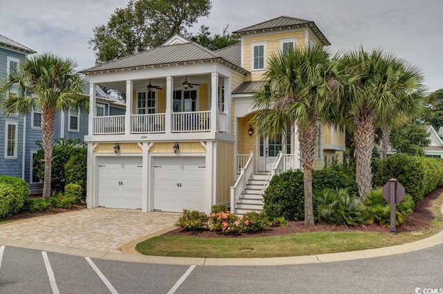 beach home with covered porch, ceiling fan, and a garage