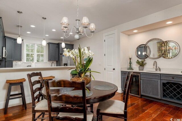 dining space with beverage cooler, sink, a notable chandelier, and dark hardwood / wood-style floors