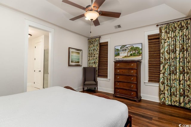 bedroom featuring visible vents, a ceiling fan, connected bathroom, wood finished floors, and baseboards