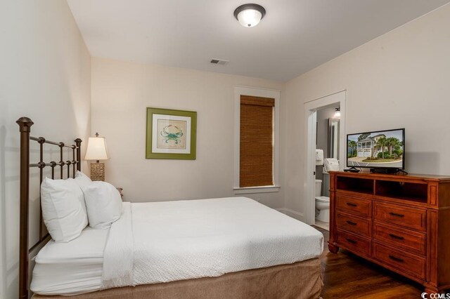 bedroom featuring dark hardwood / wood-style flooring and ensuite bathroom