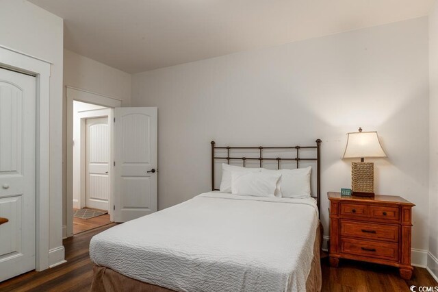 bedroom with dark hardwood / wood-style floors