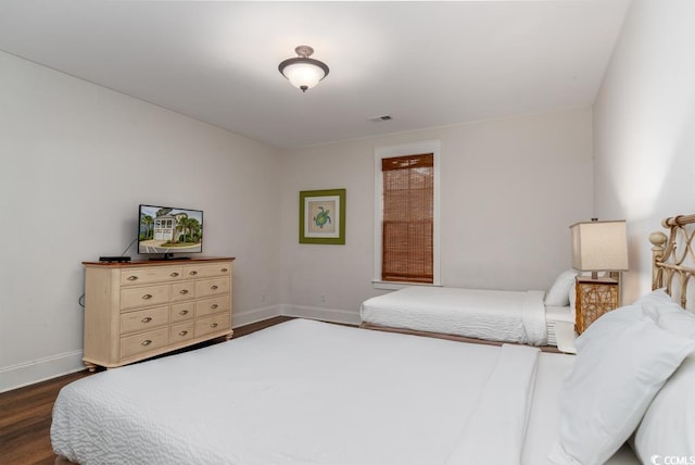 bedroom with dark wood-type flooring