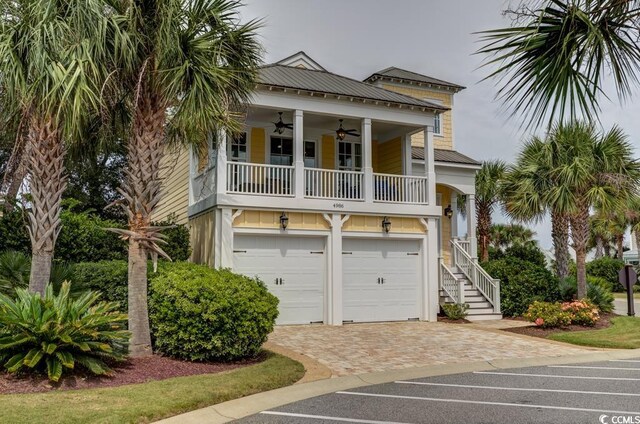 raised beach house with a garage and ceiling fan