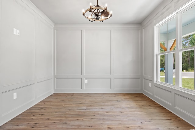 unfurnished dining area featuring light hardwood / wood-style floors and a chandelier