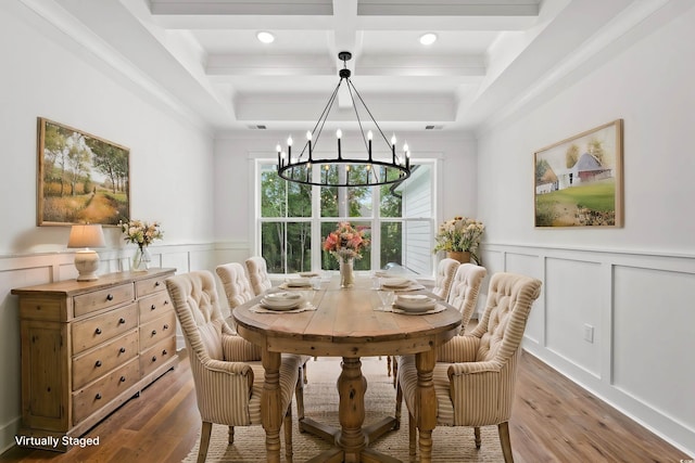 dining space with light hardwood / wood-style floors, an inviting chandelier, coffered ceiling, beamed ceiling, and crown molding