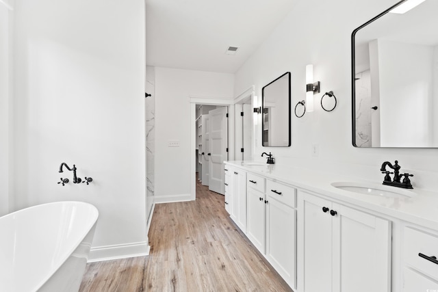 bathroom with vanity, hardwood / wood-style flooring, and a washtub