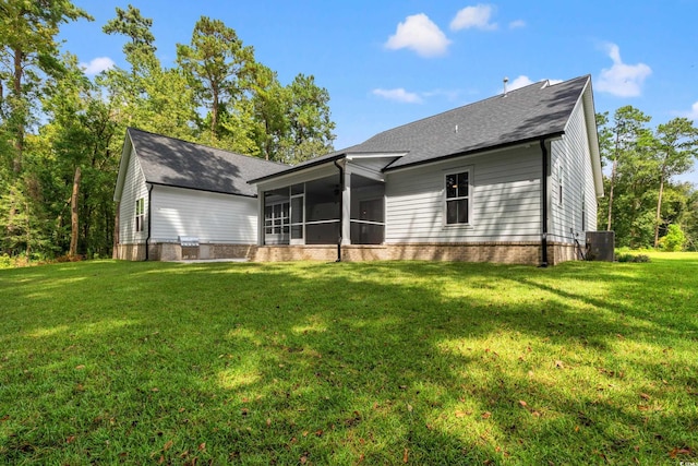 back of property with central AC unit, a sunroom, and a lawn