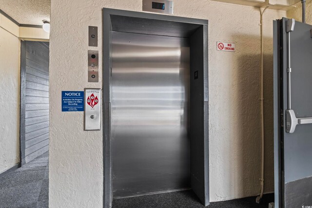 details featuring a textured ceiling and elevator